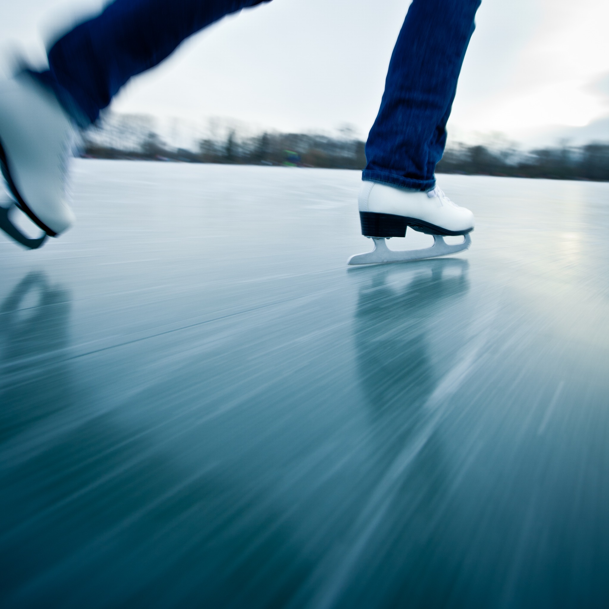 White figure skates gliding across the ice